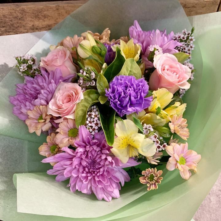 A Bouquet Of Purple And Pink Flowers Wrapped In Green Paper — The House of Flowers In Kirwan, QLD 