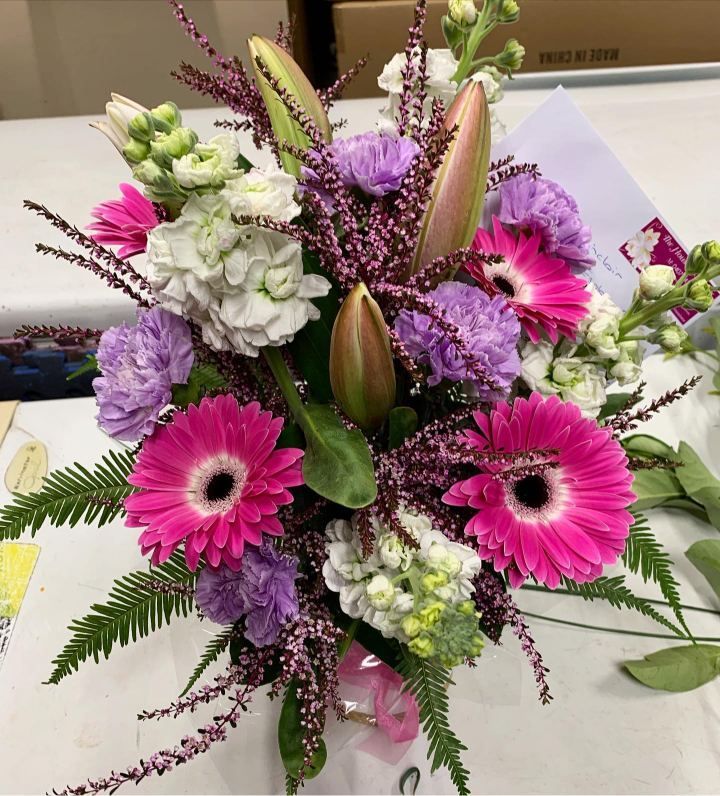 A Bouquet Of Pink And Purple Flowers On A Table — The House of Flowers In Kirwan, QLD 
