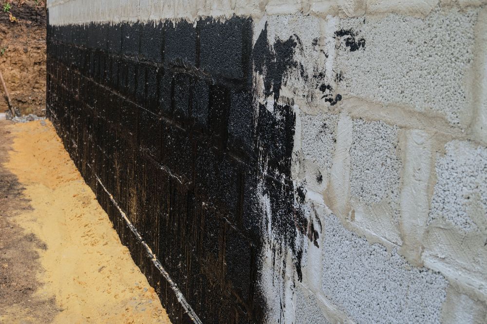 A Brick Wall Is Being Painted Black And White — Eldred Waterproofing In Gordonvale, QLD