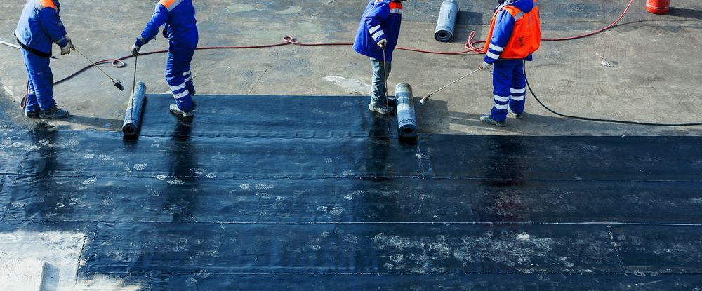 A Group Of People Are Working On A Roof — Eldred Waterproofing In Gordonvale, QLD