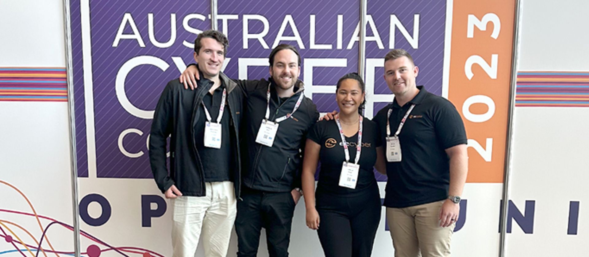 Our cyber security recruitment team standing in front of the ASIA CyberCon 2023 sign