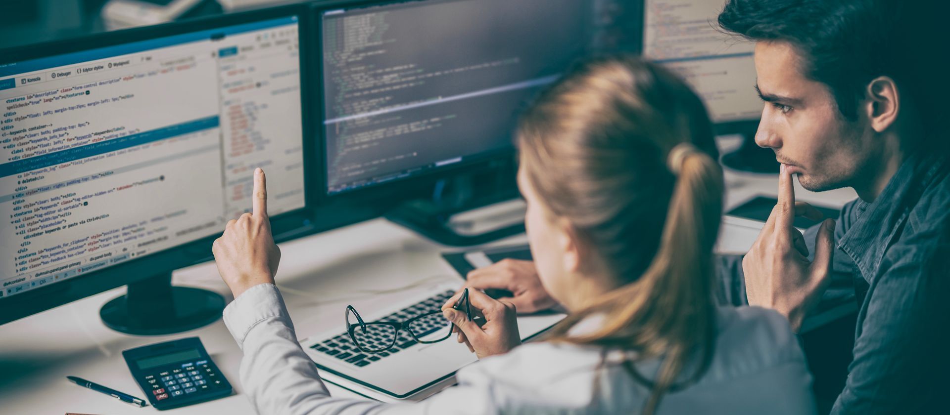 two cyber security professionals looking at a computer monitor