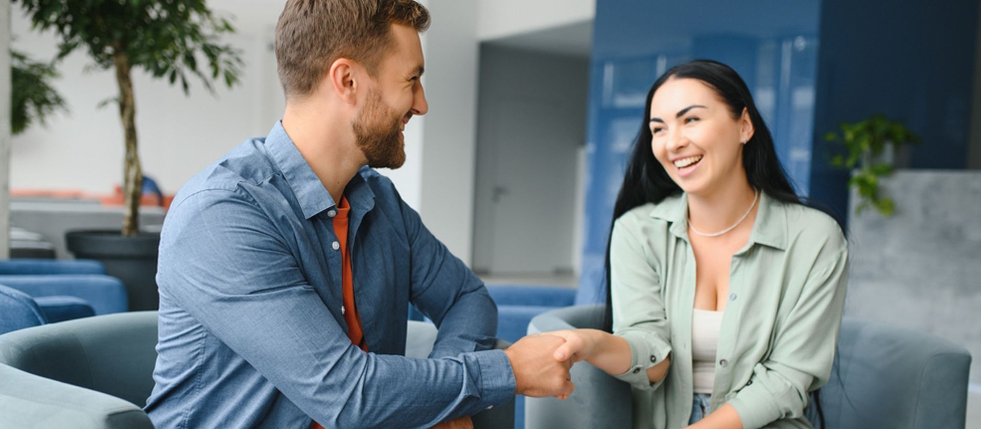 A woman talking to a man holding his laptop