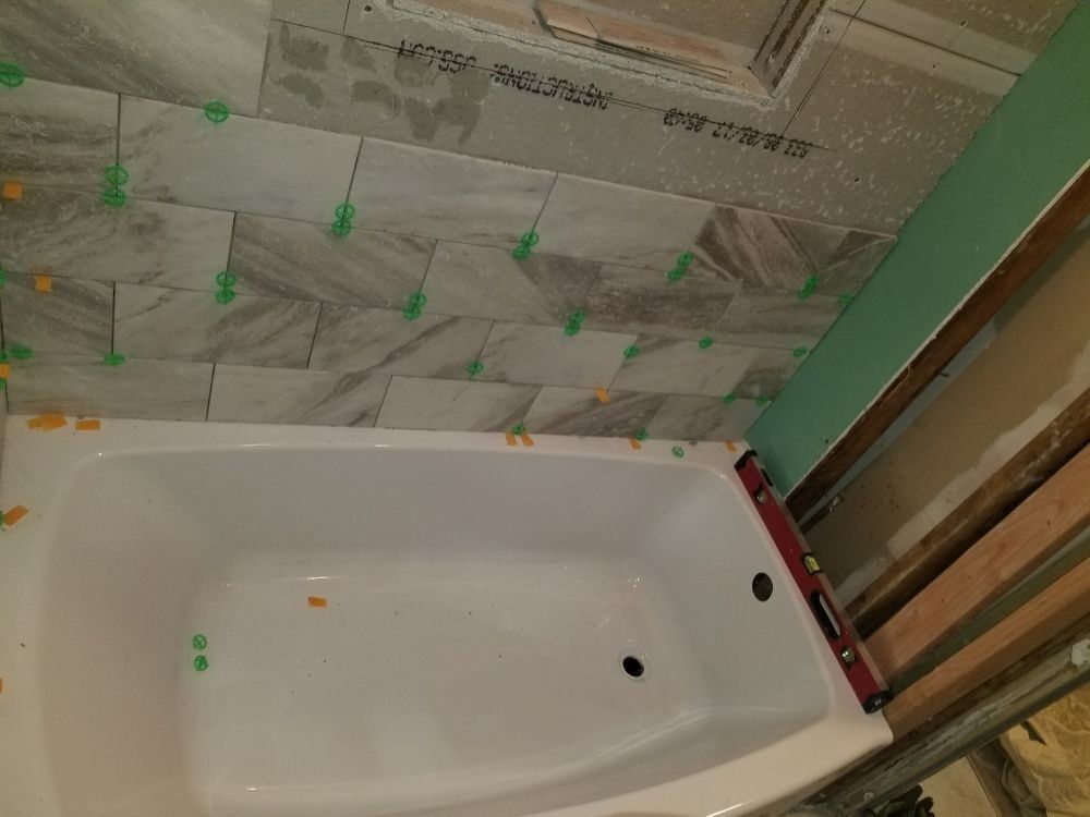 A bathtub is sitting in a bathroom under construction.