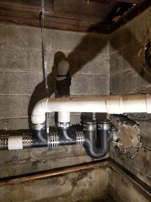 A bunch of pipes are connected to each other in a basement.