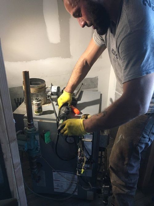 A man is working on an air conditioner in a room.