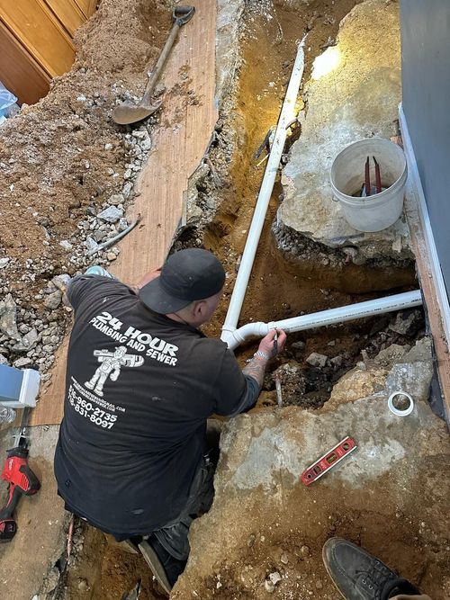 Two men are working on a pipe in a basement.
