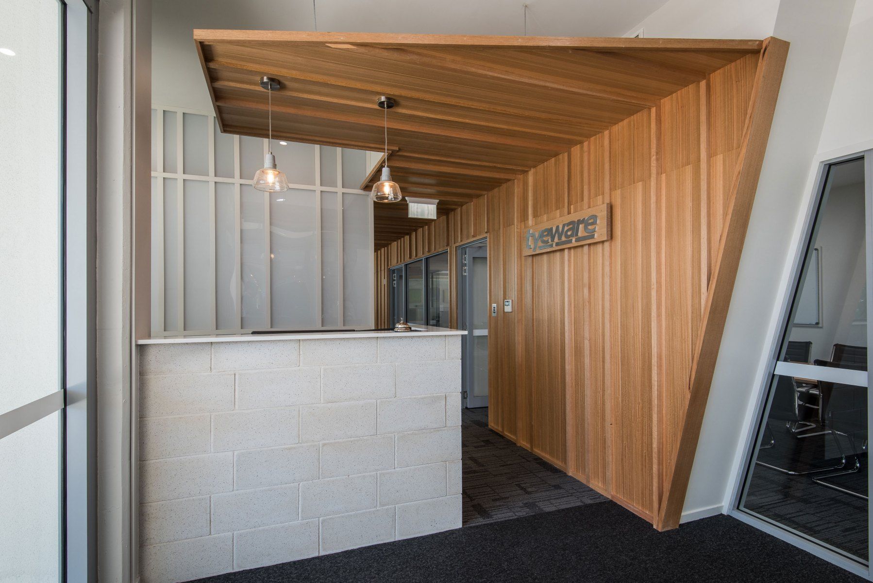 Reception Area With a White Brick Counter, Wood Paneling, and Two Hanging Lights — BOLD Architecture + Interior Design In Mackay, QLD