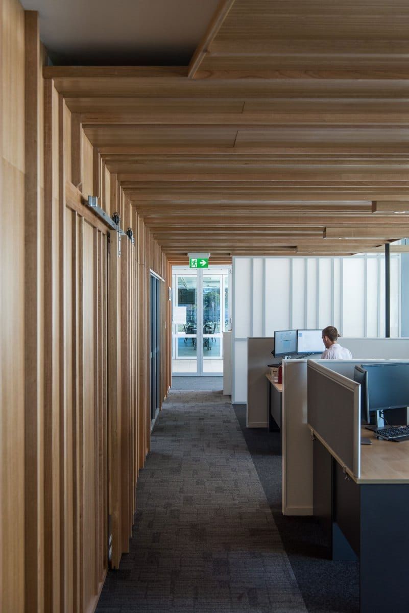 Office Hallway With Wooden Paneling, Desks, and Exit Door — BOLD Architecture + Interior Design In Mackay, QLD