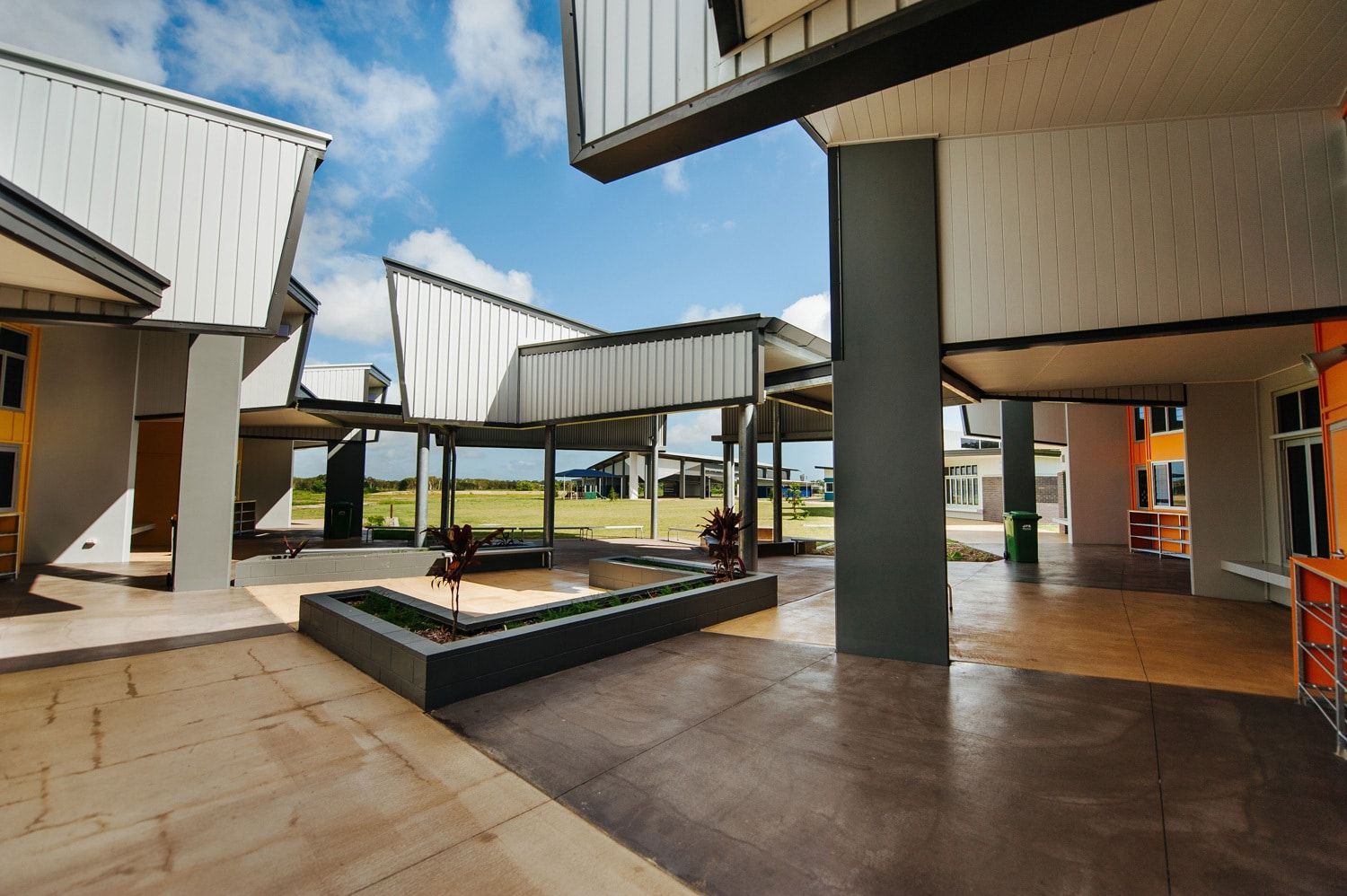 Modern Building Exterior With Gray Pillars and White Structures, Under a Bright Blue Sky — BOLD Architecture + Interior Design In Mackay, QLD