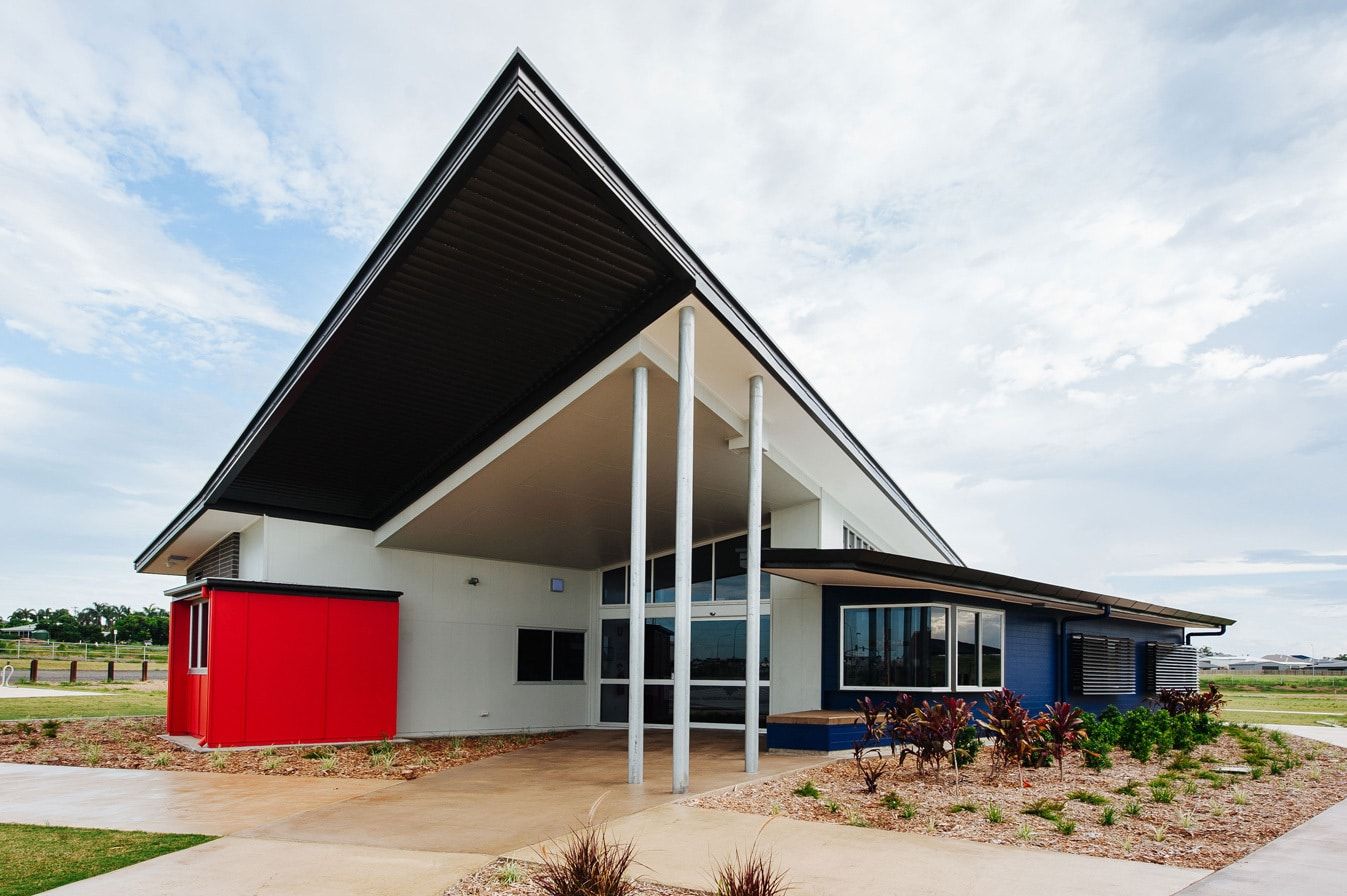 Modern, Angular Building With Red and Blue Accents, Large Roof Overhang Supported by White Pillars — BOLD Architecture + Interior Design In Mackay, QLD