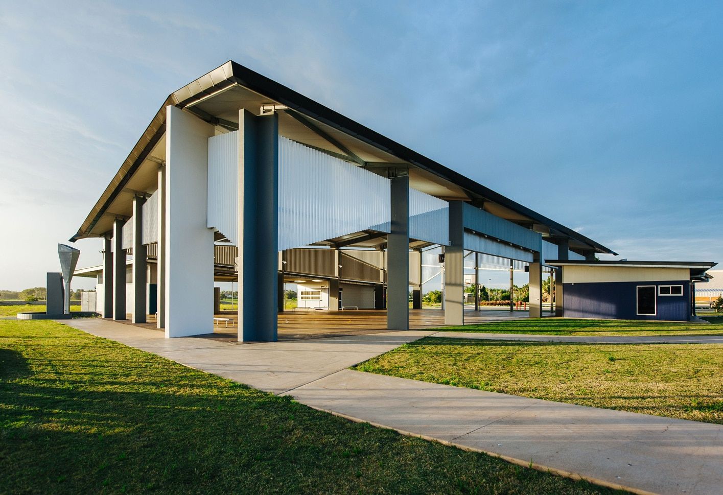 Modern Building With Blue and White Supports, on a Grassy Area With a Pathway — BOLD Architecture + Interior Design In Mackay, QLD