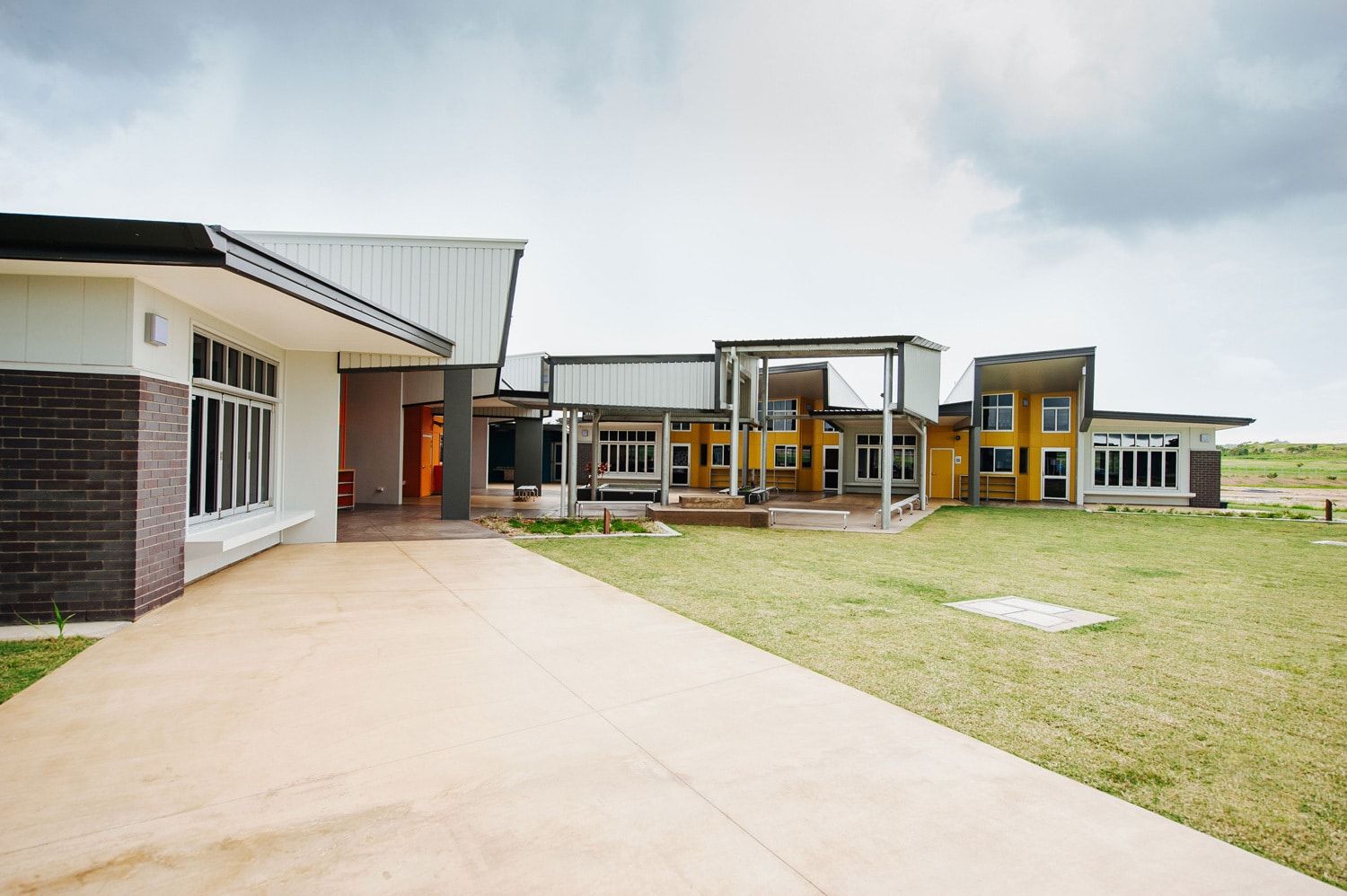 Modern Yellow and White Building With a Flat Roof, and a Concrete Driveway — BOLD Architecture + Interior Design In Mackay, QLD