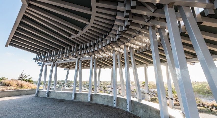 An Architectural Outdoor Shelter With a Curved Roof Supported by Vertical Beams — BOLD Architecture + Interior Design In Mackay, QLD