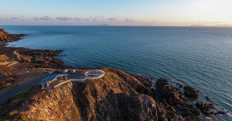 Coastal View: Rocky Shoreline With a Round Viewing Platform, Blue Sea, and Distant Islands Under a Pale Sky — BOLD Architecture + Interior Design In Mackay, QLD
