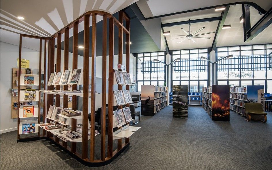 Library Interior With Bookshelves, Natural Wood Accents, and Large Windows — BOLD Architecture + Interior Design In Mackay, QLD