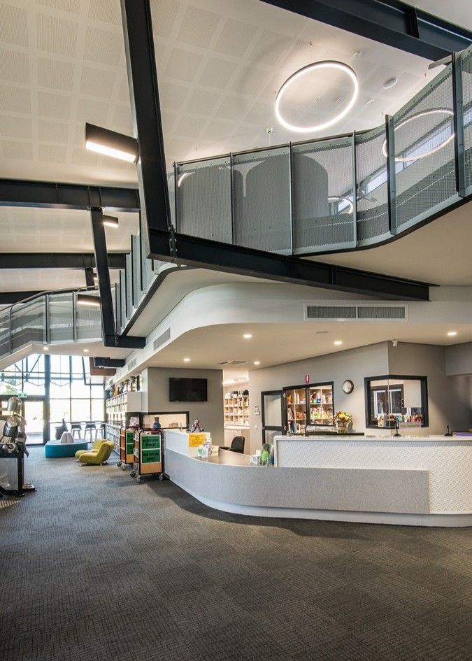 Modern Library Interior With Reception Desk, Gray Carpet, and a Second Level Walkway — BOLD Architecture + Interior Design In Mackay, QLD
