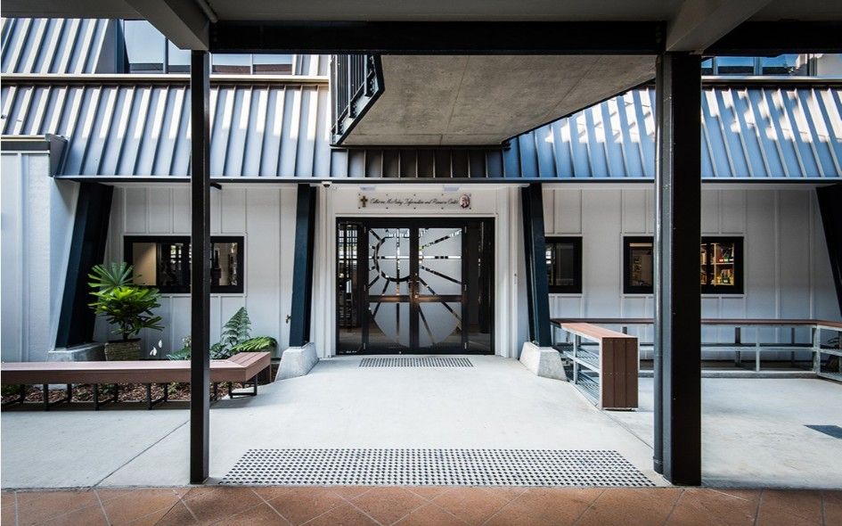 Courtyard Entrance to a Building With Glass Doors, Benches, and Gray and Black Architecture — BOLD Architecture + Interior Design In Mackay, QLD