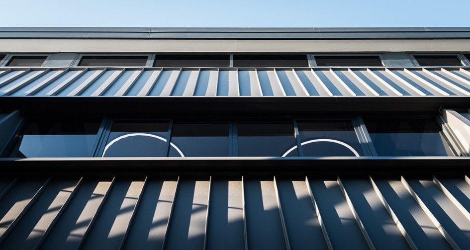 Low-angle View of a Modern Building With Metal Siding and Windows, Against a Blue Sky — BOLD Architecture + Interior Design In Mackay, QLD