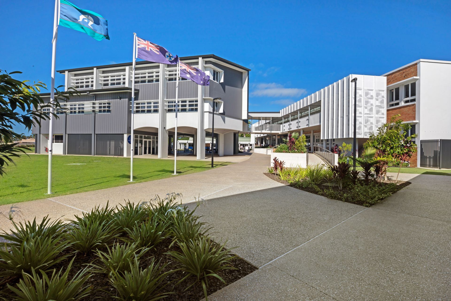 School Buildings With Flags Waving on a Sunny Day — BOLD Architecture + Interior Design In Mackay, QLD
