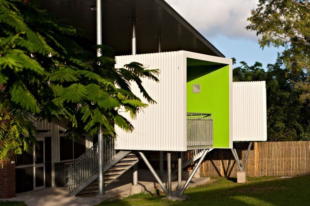 Modern White and Green Building With a Raised Section, Metal Supports, and a Stairway — BOLD Architecture + Interior Design In Mackay, QLD