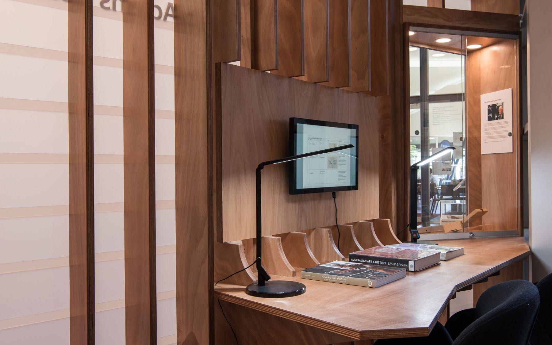 Wooden Desk With Computer, Lamp, and Books; An Entryway With Display Case — BOLD Architecture + Interior Design In Mackay, QLD