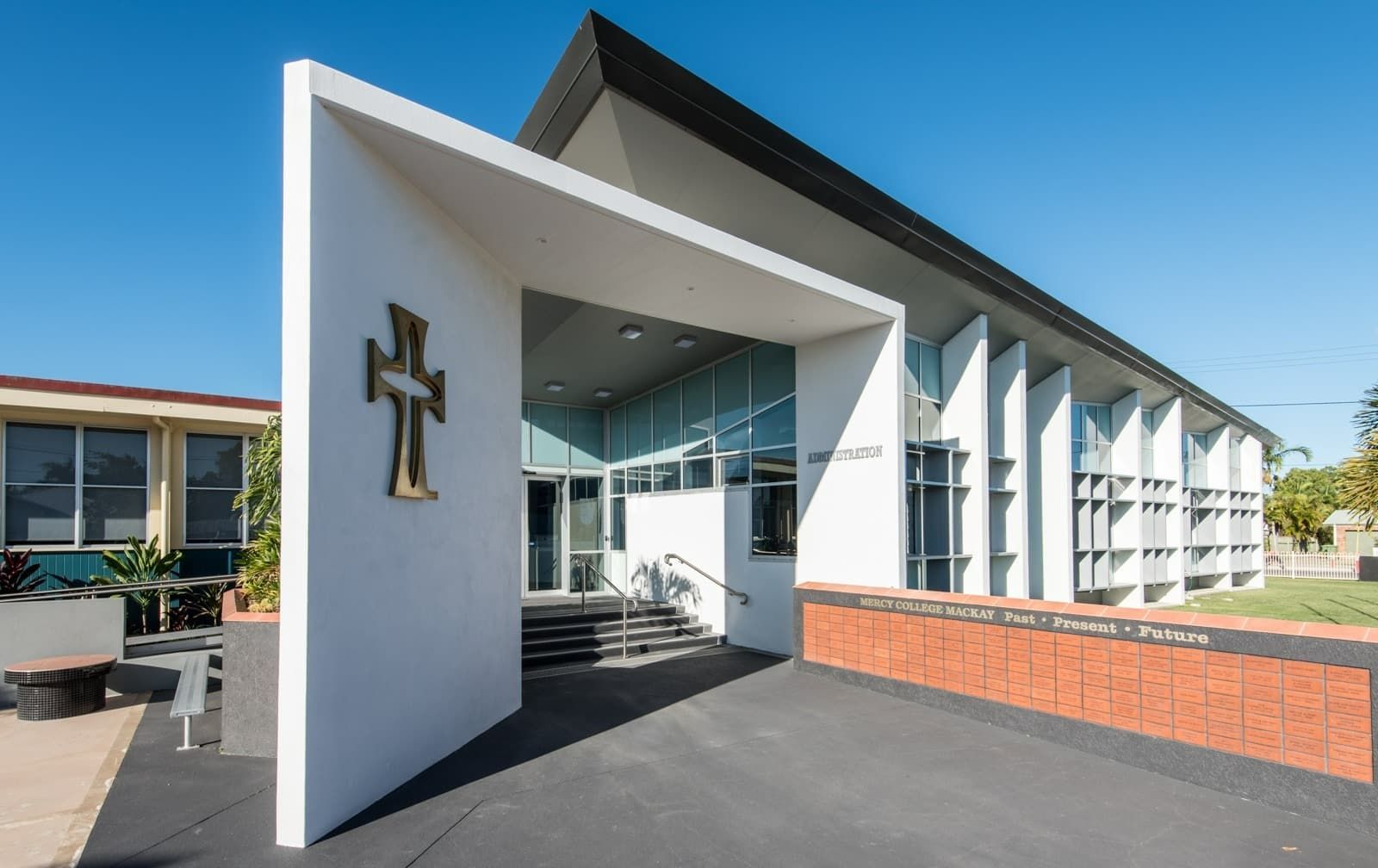 Modern Building Entrance with White Walls, a Cross, and Glass Doors. Blue Sky and Sunny Day — BOLD Architecture + Interior Design In Mackay, QLD