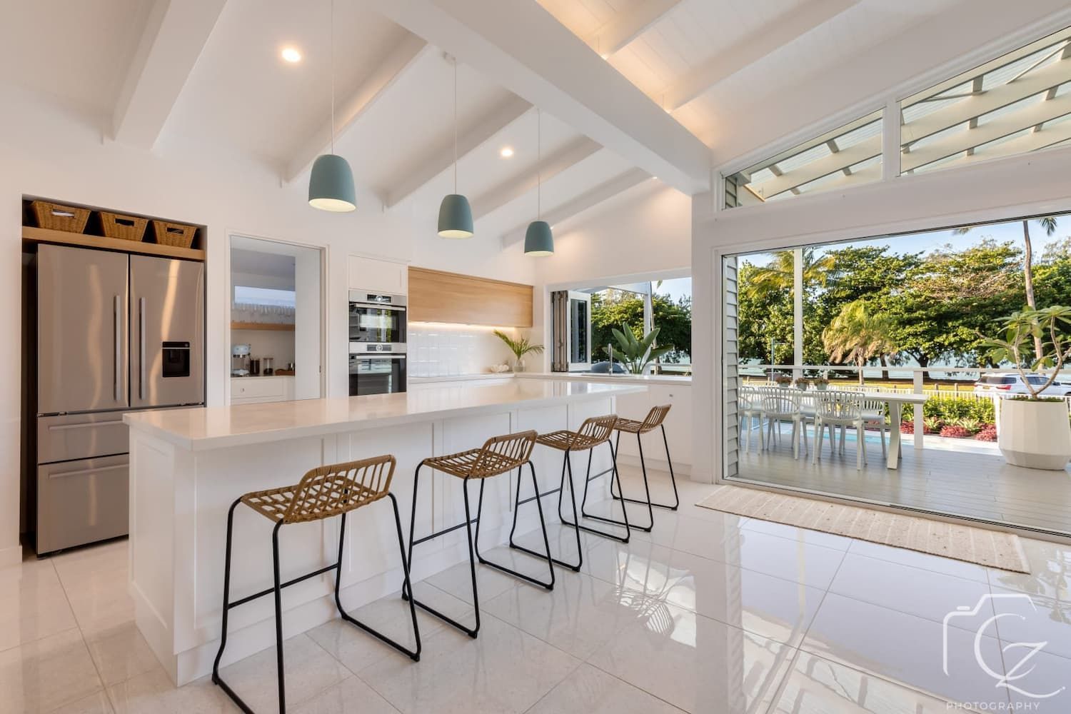 Bright Kitchen with Island Seating and Outdoor Views — BOLD Architecture + Interior Design In Mackay, QLD.