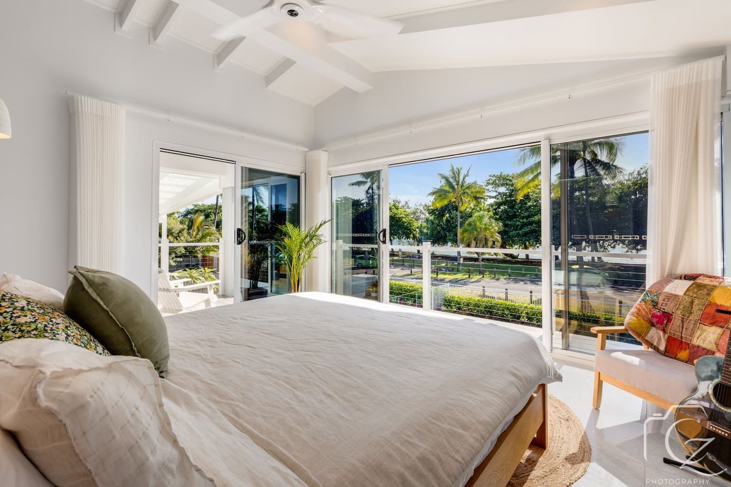 Bright Bedroom with Bed, Open Sliding Doors, and View of Green Trees — BOLD Architecture + Interior Design In Mackay, QLD