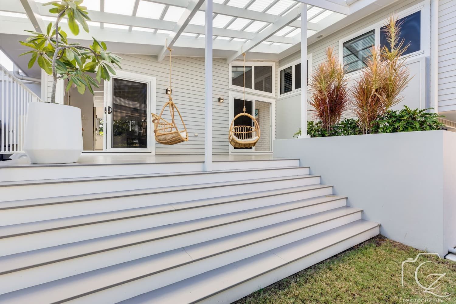 White Outdoor Deck with Steps, Pergola, and Hanging Chairs — BOLD Architecture + Interior Design In Mackay, QLD