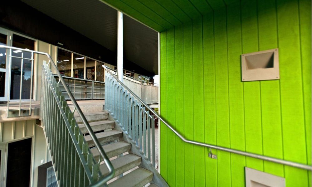 Stairwell With Stairs, Green Wall, and Metal Railing — BOLD Architecture + Interior Design In Mackay, QLD