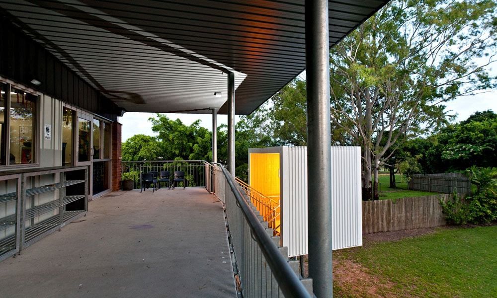 A Shaded Outdoor Patio With a Metal Railing, Overlooking a Grassy Yard and Trees — BOLD Architecture + Interior Design In Mackay, QLD