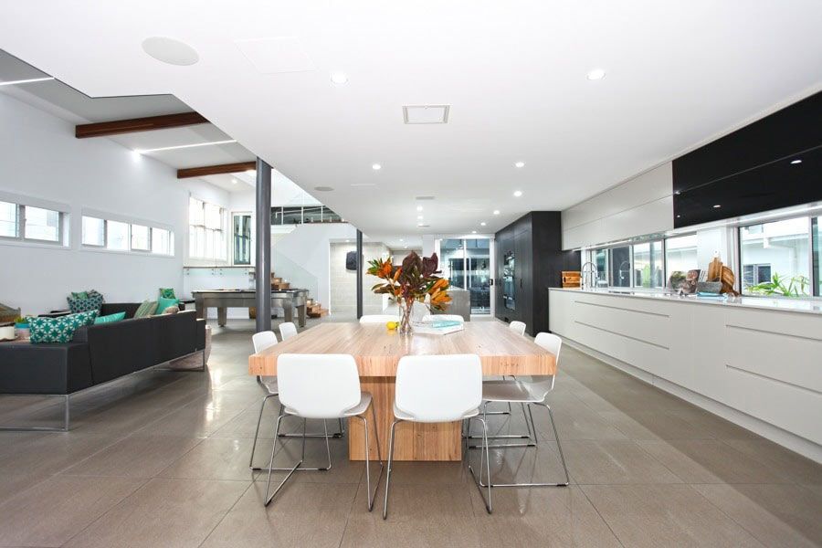 A Kitchen With A Large Wooden Table And White Chairs — BOLD Architecture + Interior Design In Mackay, QLD