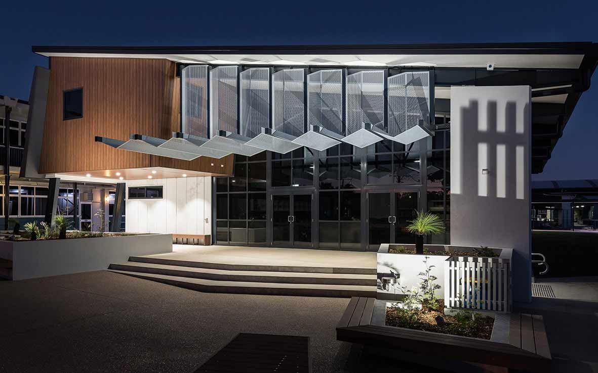 A Large Building With A Lot Of Windows Is Lit Up At Night — BOLD Architecture + Interior Design In Mackay, QLD