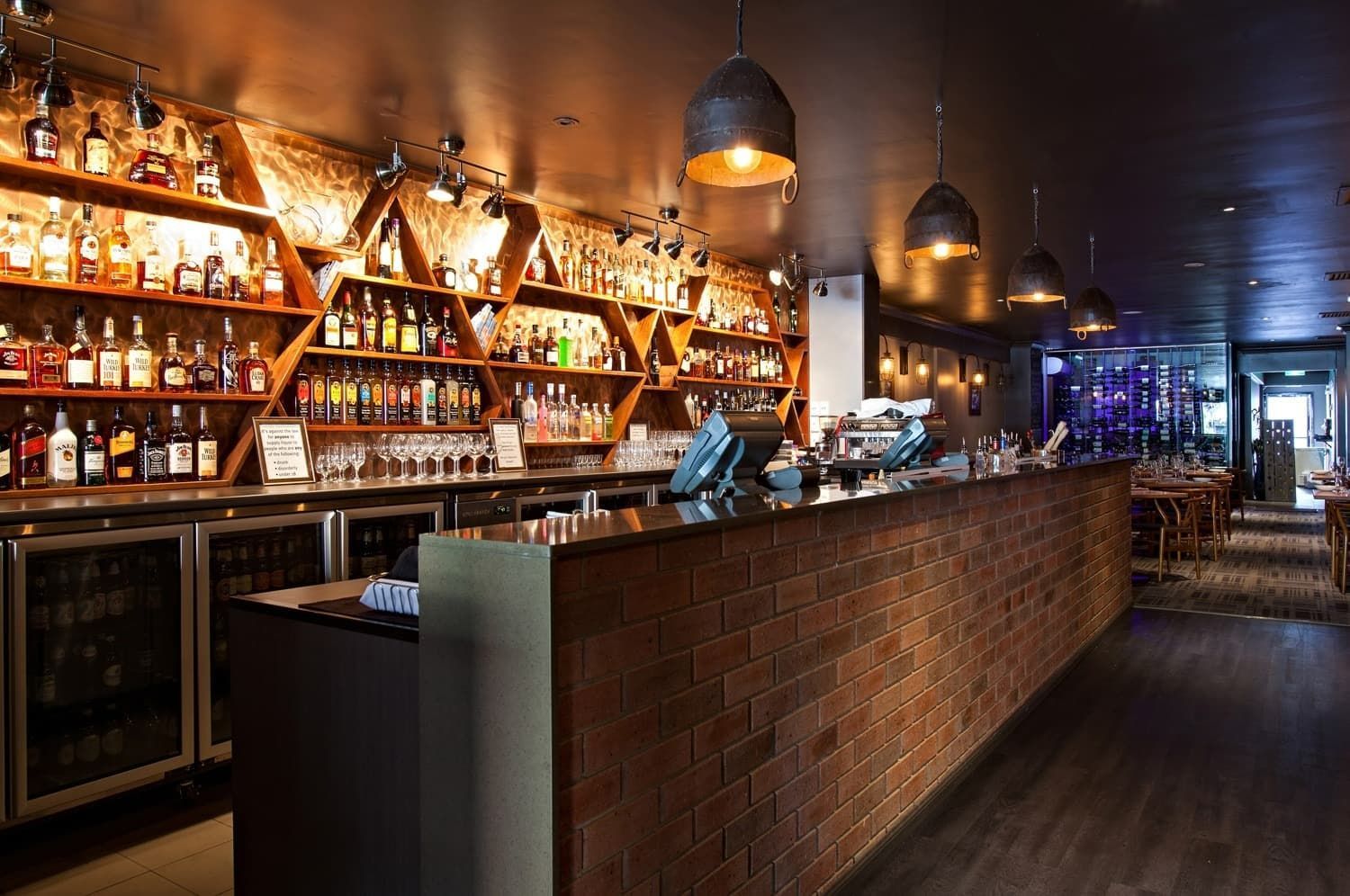Bar Interior with Brick Wall, Liquor Shelves, and Hanging Lights — BOLD Architecture + Interior Design In Mackay, QLD