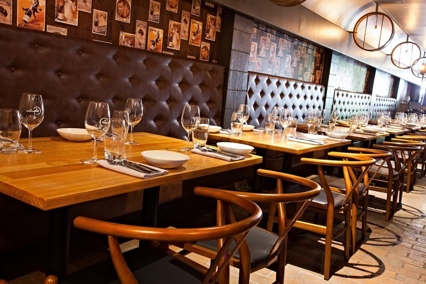 Restaurant Interior with Wooden Tables, Chairs, and A Tufted Brown Leather Wall — BOLD Architecture + Interior Design In Mackay, QLD