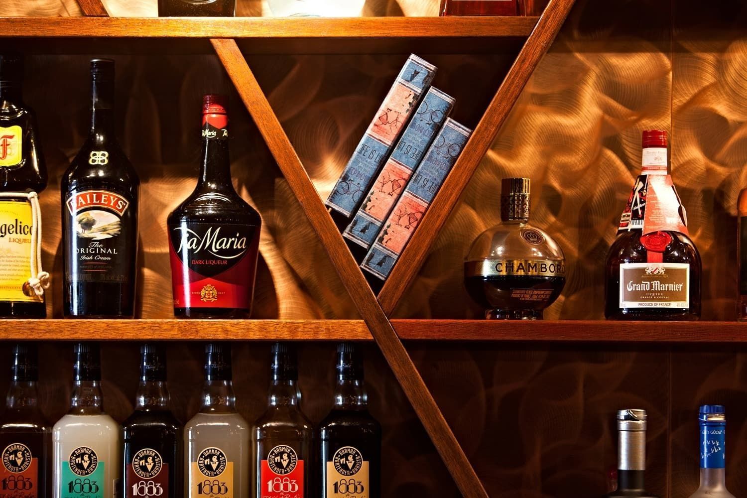 Liquor Bottles on Wooden Shelves, Including Baileys and Other Spirits — BOLD Architecture + Interior Design In Mackay, QLD