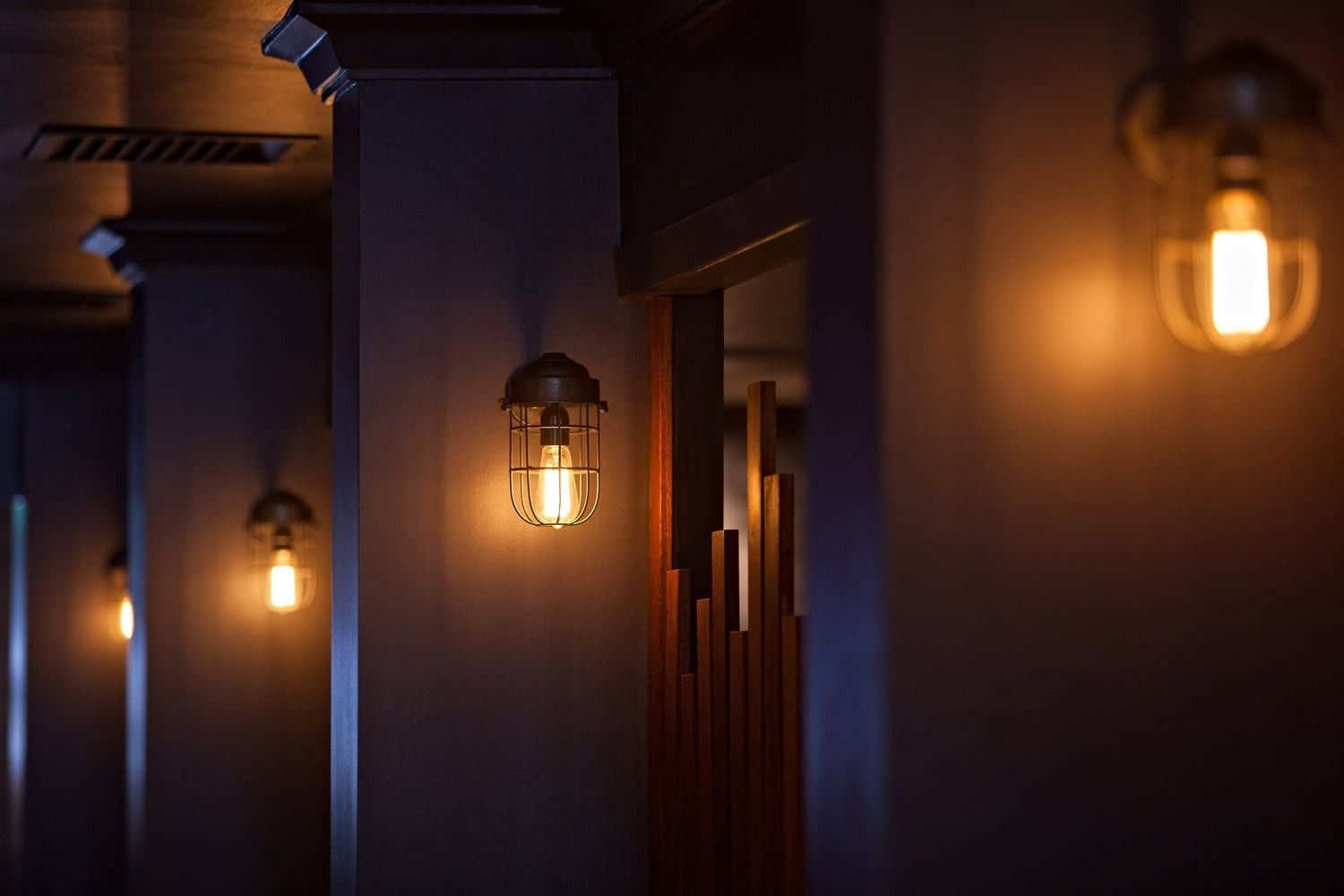 Dimly Lit Room with Warm Light Fixtures on Pillars — BOLD Architecture + Interior Design In Mackay, QLD