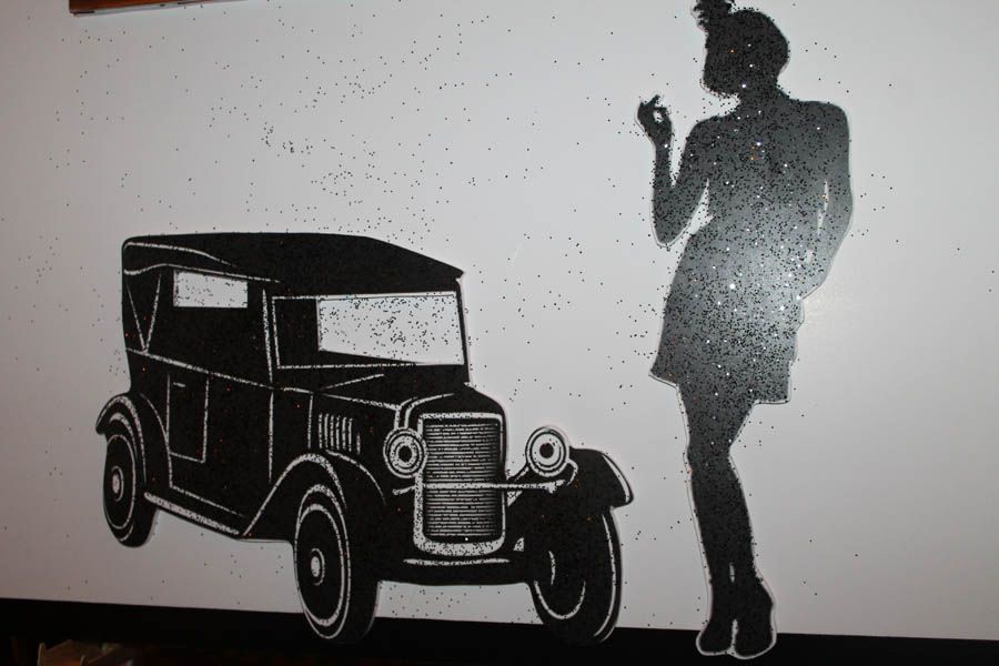 Black car and woman silhouette on white wall.