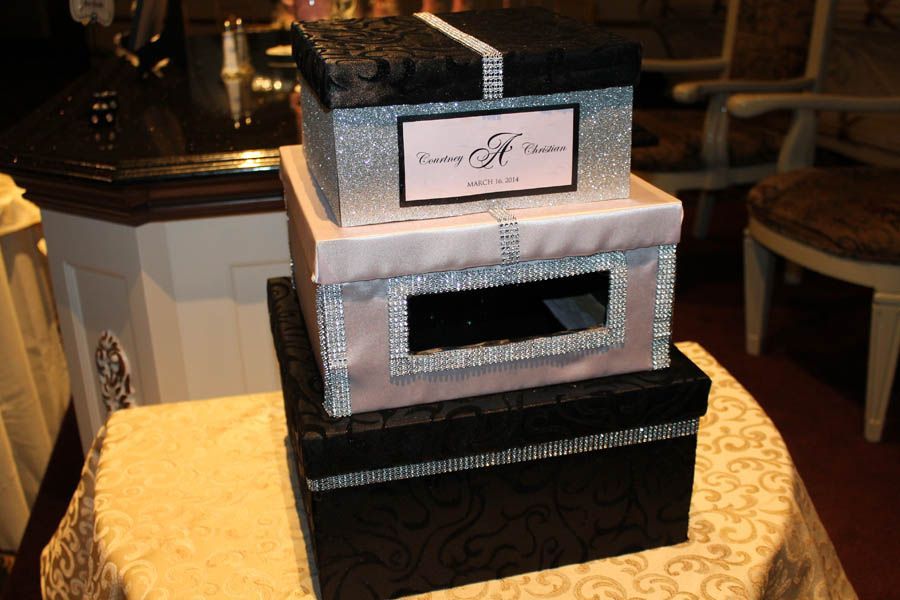 Stacked, decorative boxes; black and pink, with jewel trim; for a wedding gift table.