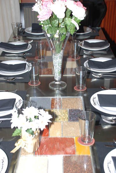 Formal dining table set for a meal, with floral arrangements and place settings.