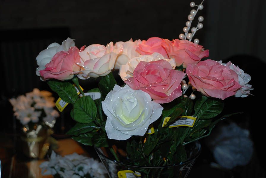 Close-up of a bouquet of pink and white artificial roses with a clear vase.