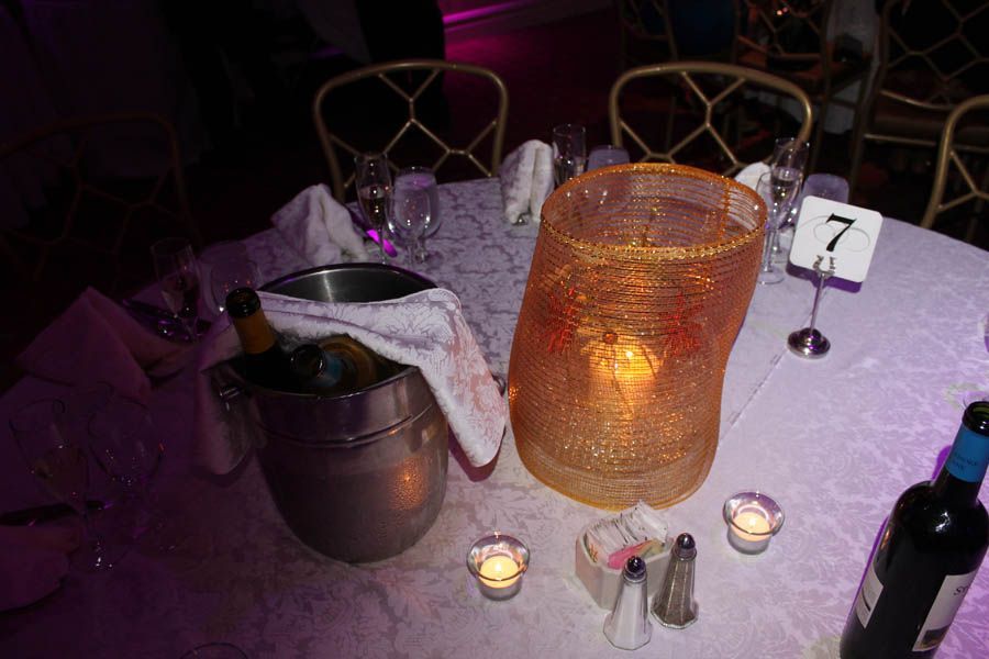 Table setting with champagne bucket, wine bottle, and decorative candle holder. Number 7 on the table.