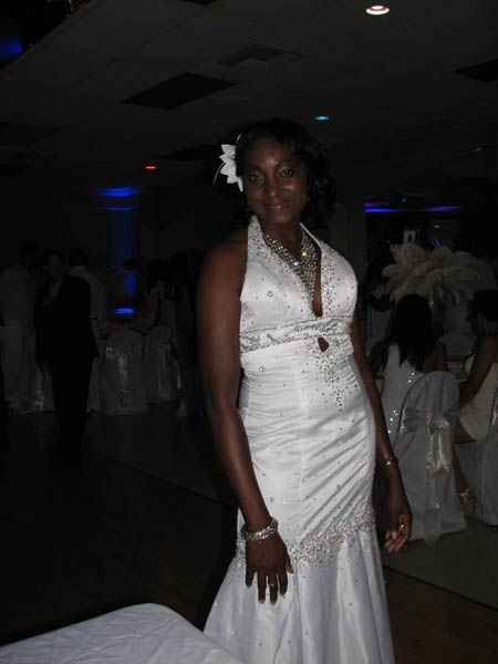 Woman in white wedding dress at event, smiling.