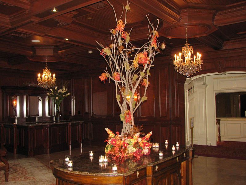 Elegant interior with wood paneling, ornate floral arrangement, and chandeliers.