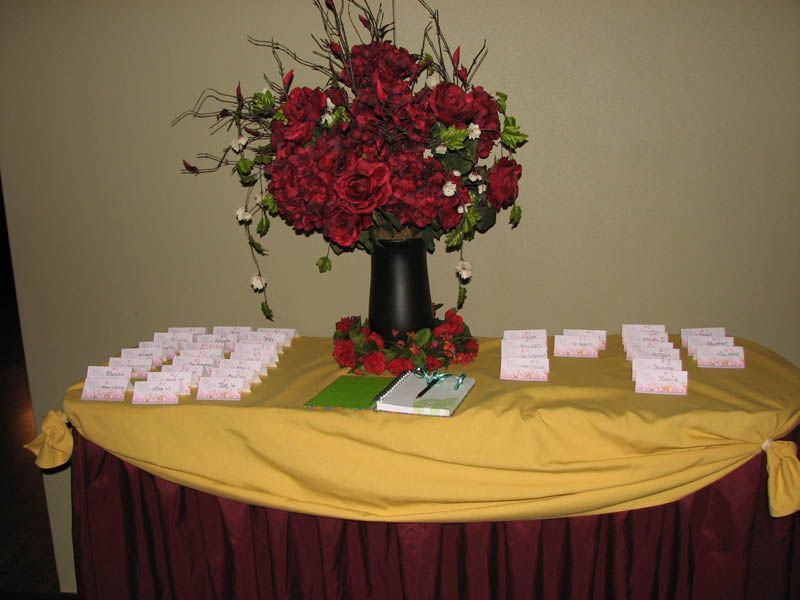 Table with red floral arrangement and place cards.