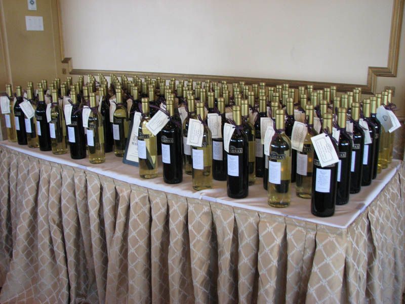Bottles of wine on a draped table, likely for tasting or sale. Labels are attached.