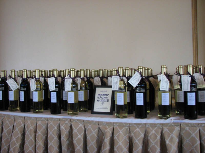 Bottles of wine on a table, with tags. Event banner in the center.