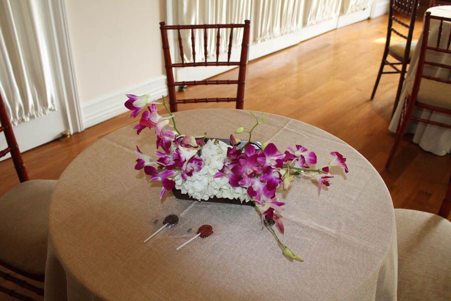 Round table with floral arrangement and chairs in a room with hardwood floors.