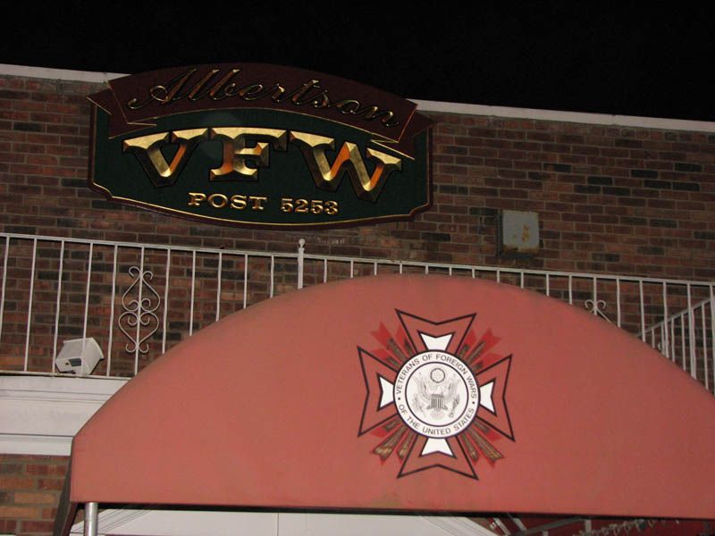 Sign for American VFW Post 5253 above an awning with a military-style emblem.